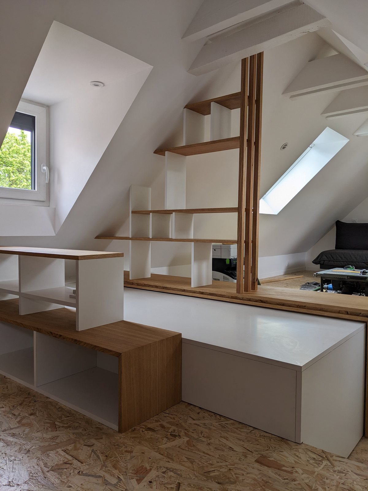 Bibliothèque sur mesure en bois et blanc intégrée sous les combles